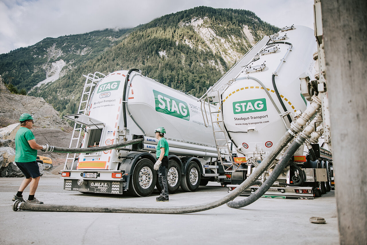 Zwei STAG Mitarbeiter bei der Arbeit vor zwei STAG LKW