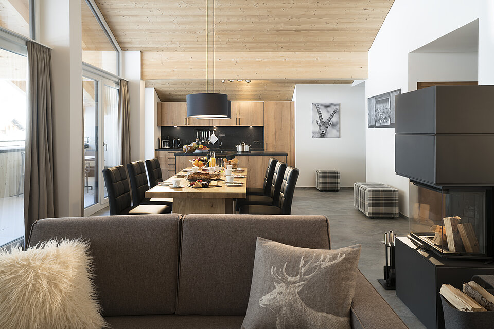 Wohn- und Essbereich mit Küche, Esstisch, Couch und Kamin